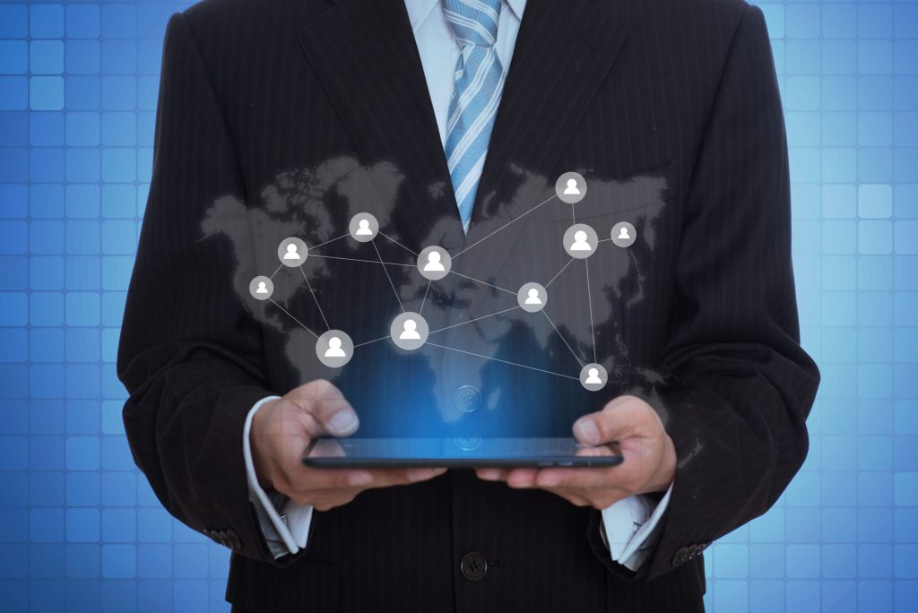 Businessman holding a tablet with virtual application icons.